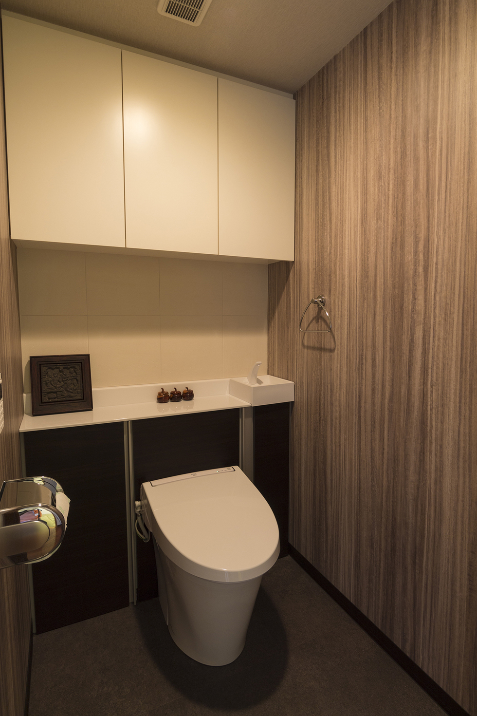 -家事がたのしくなるキッチン　マンションデザインリフォーム-トイレは収納付きのリフォレ。壁のクロスでアクセントをつけ、キャビネットの間はエコカラットでアクセントと消臭を兼ねました。