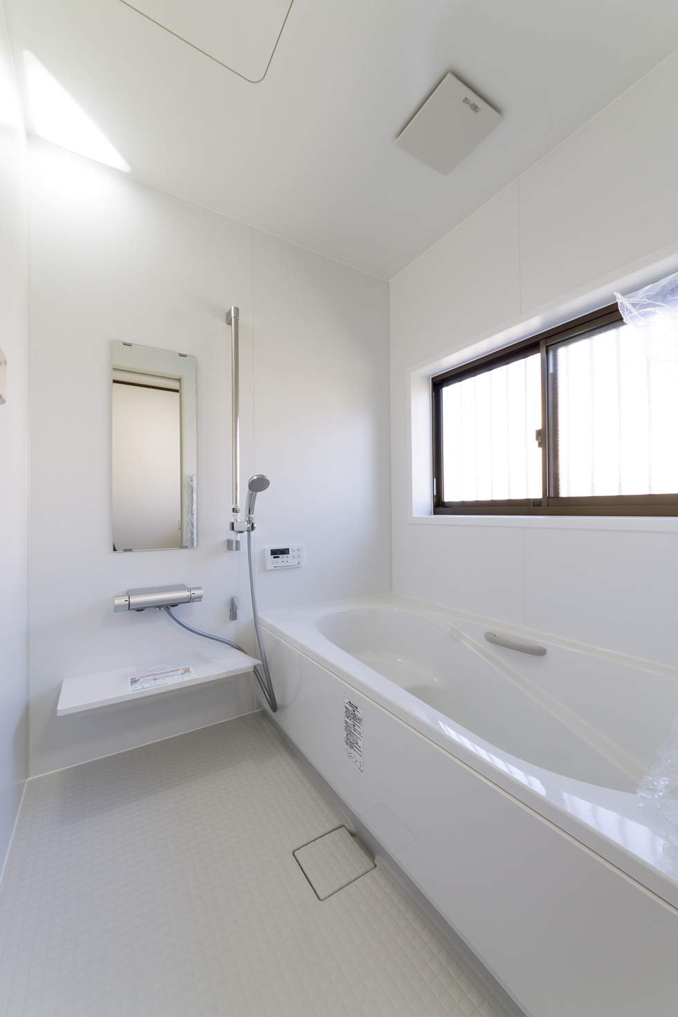 -平屋の木造住宅をライフスタイルに合わせた土間収納のある家にリフォーム-浴室は白で統一された清潔感のあるLIXIL「アライズ」に設備交換。
お湯が真上からふりそそぐオーバーヘッドシャワーは、空気を含んだお湯がでてくる節水シャワーになっています。