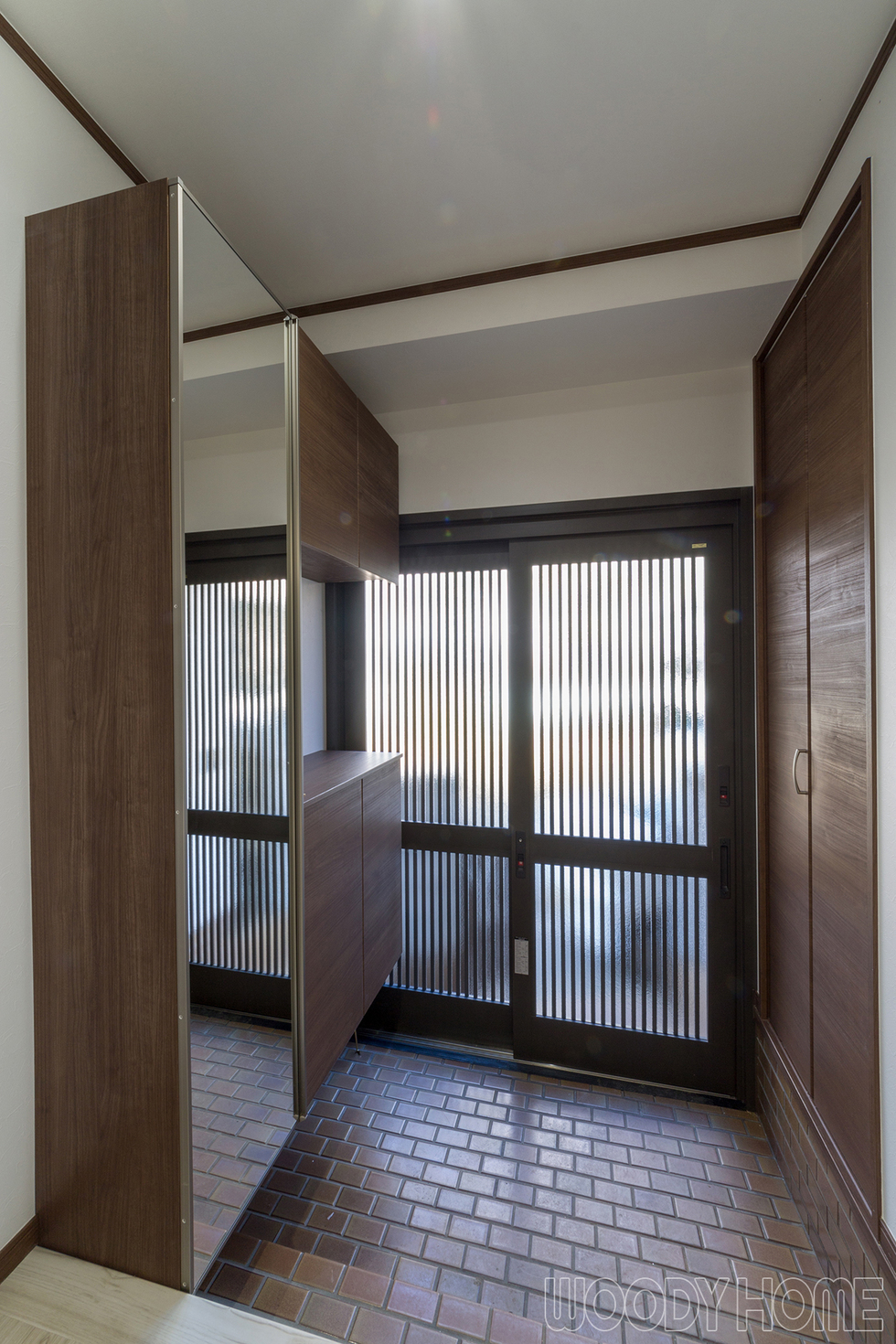 -木造住宅を耐震と間取り変更リノベーションで二世帯が暮らしやすい家に-玄関引き戸も新しくなった玄関。左はフロート収まり（床から浮かして取り付け）の下駄箱、右はシューズインクローゼットです。履物だけでなくお父さんのゴルフバッグやアウトドア用品などを入れます。